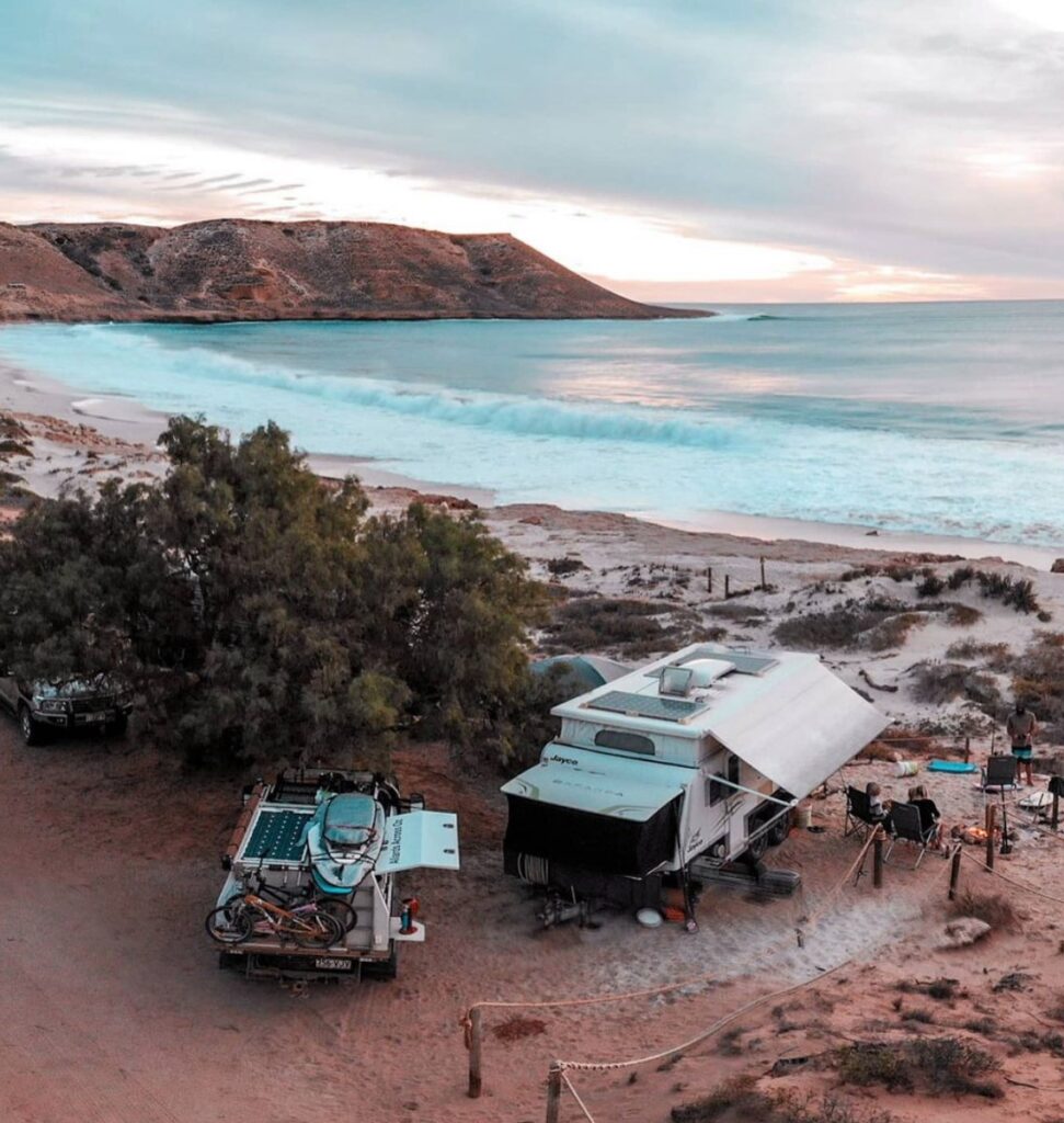 Caravan parked by the beach with ocean view at sunset