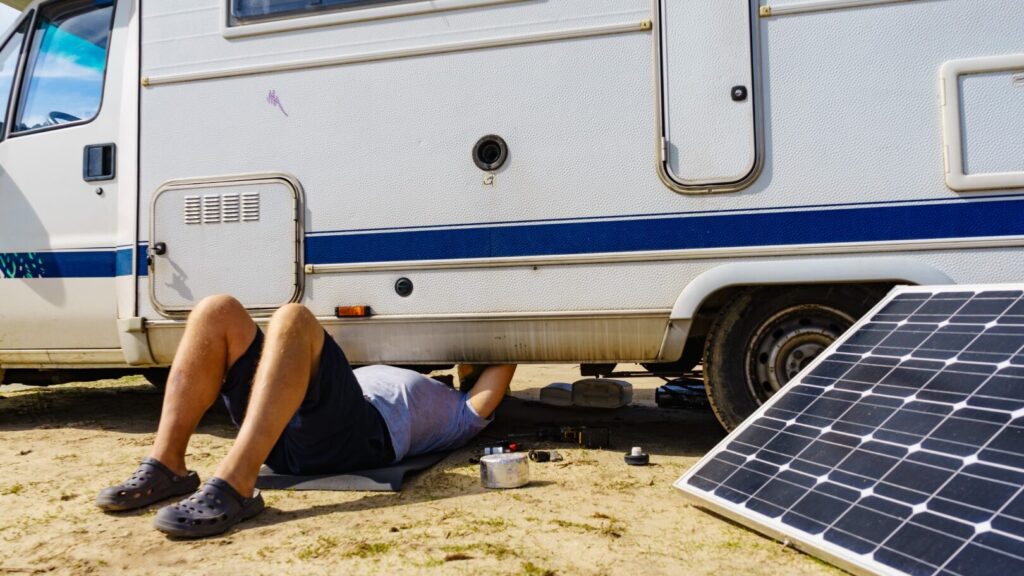 Man repairing bottom of the rv caravan.