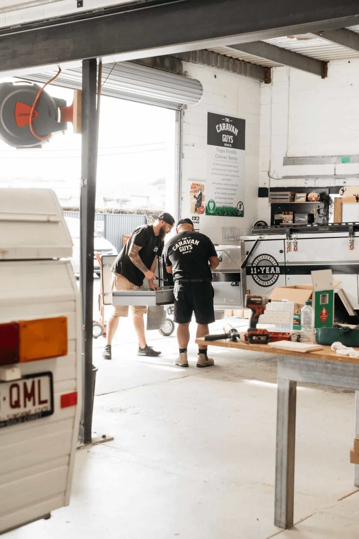 Technicians working on a caravan drawer system in workshop.