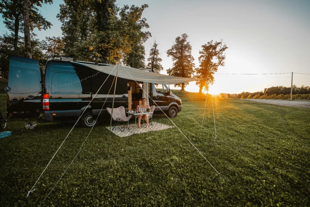 A caravan with its awning open at sunset